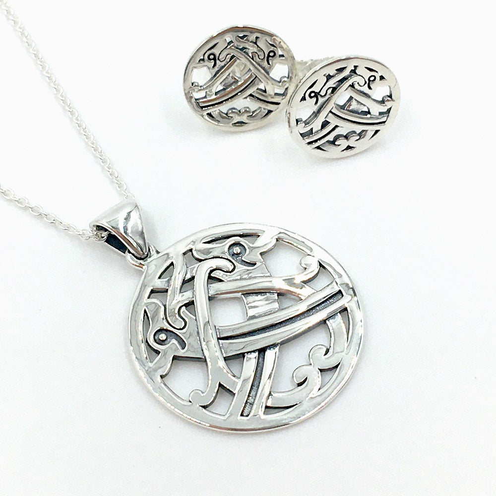 Round silver stud earrings and a silver pendant with an intertwined beast design taken from a detail of a brooch found in the Galloway hoard.