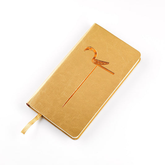 A gold imitation leather bound notebook with a gold embossed design of a bird pin from the Galloway hoard.