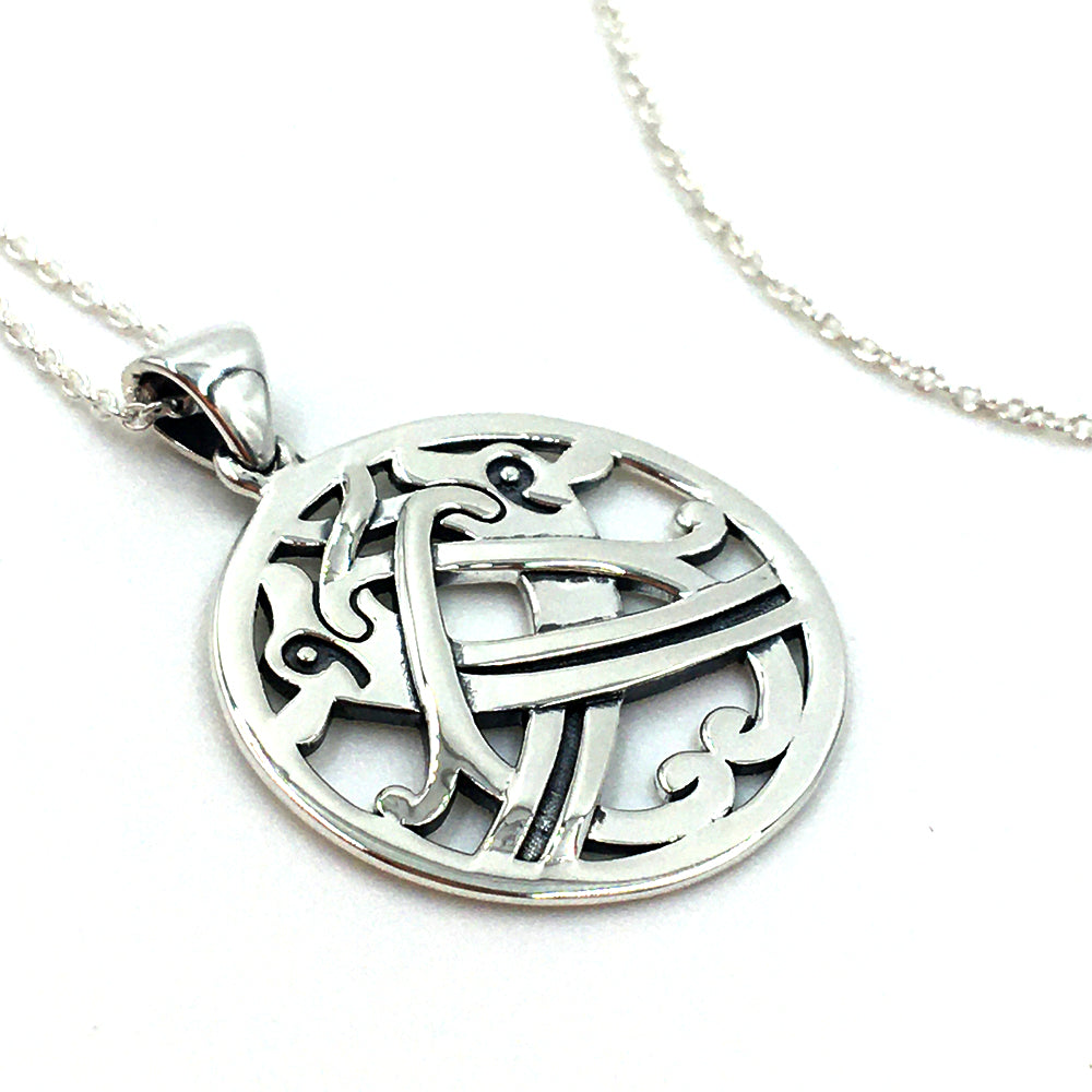 Round silver stud earrings and a silver pendant with an intertwined beast design taken from a detail of a brooch found in the Galloway hoard.