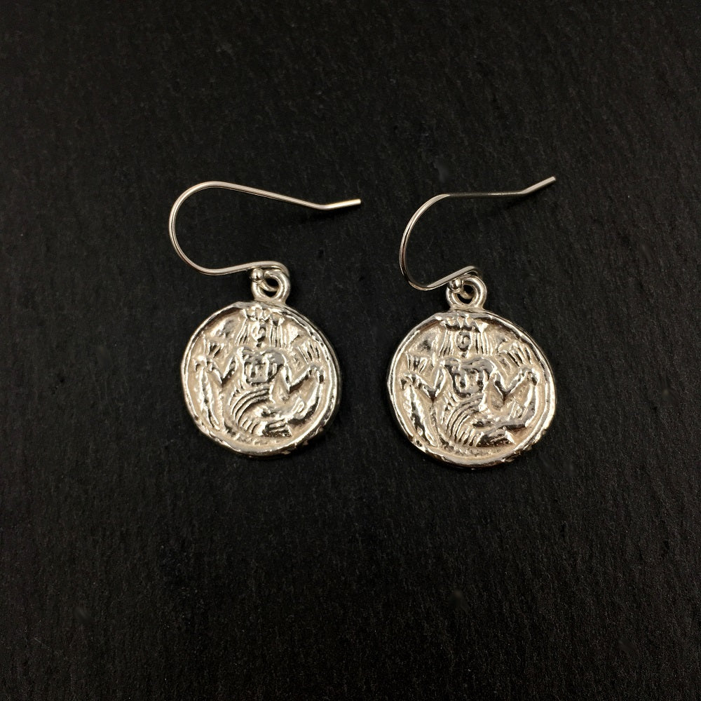 Sterling silver drop earrings depicting an ivory game counter from the 15th or 16th century. The round counter has a mermaid wearing a crown and holding a larger fish by the tail in each hand.