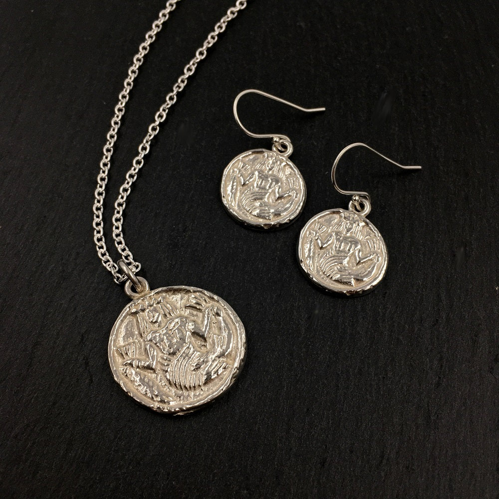 Sterling silver drop earrings and necklace depicting an ivory game counter from the 15th or 16th century. The round counter has a mermaid wearing a crown and holding a larger fish by the tail in each hand.