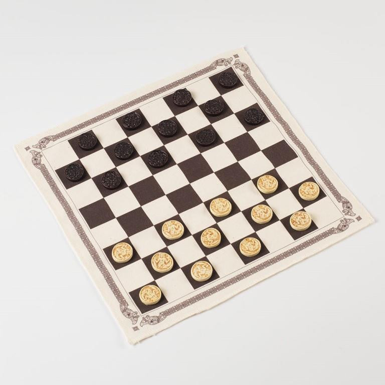 A square cloth chess board border by Norse knot work with black and white counters inspired by Norse knot work and designs.