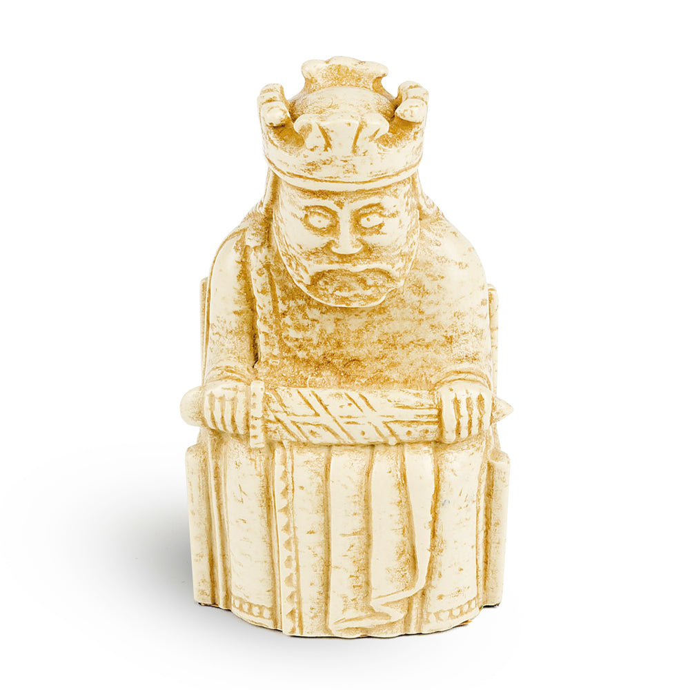 A resin replica of a king Lewis chess piece. The king is wearing long robes and a crown and is sitting on a throne decorated with knot work. He is holding a sword across his knee.
