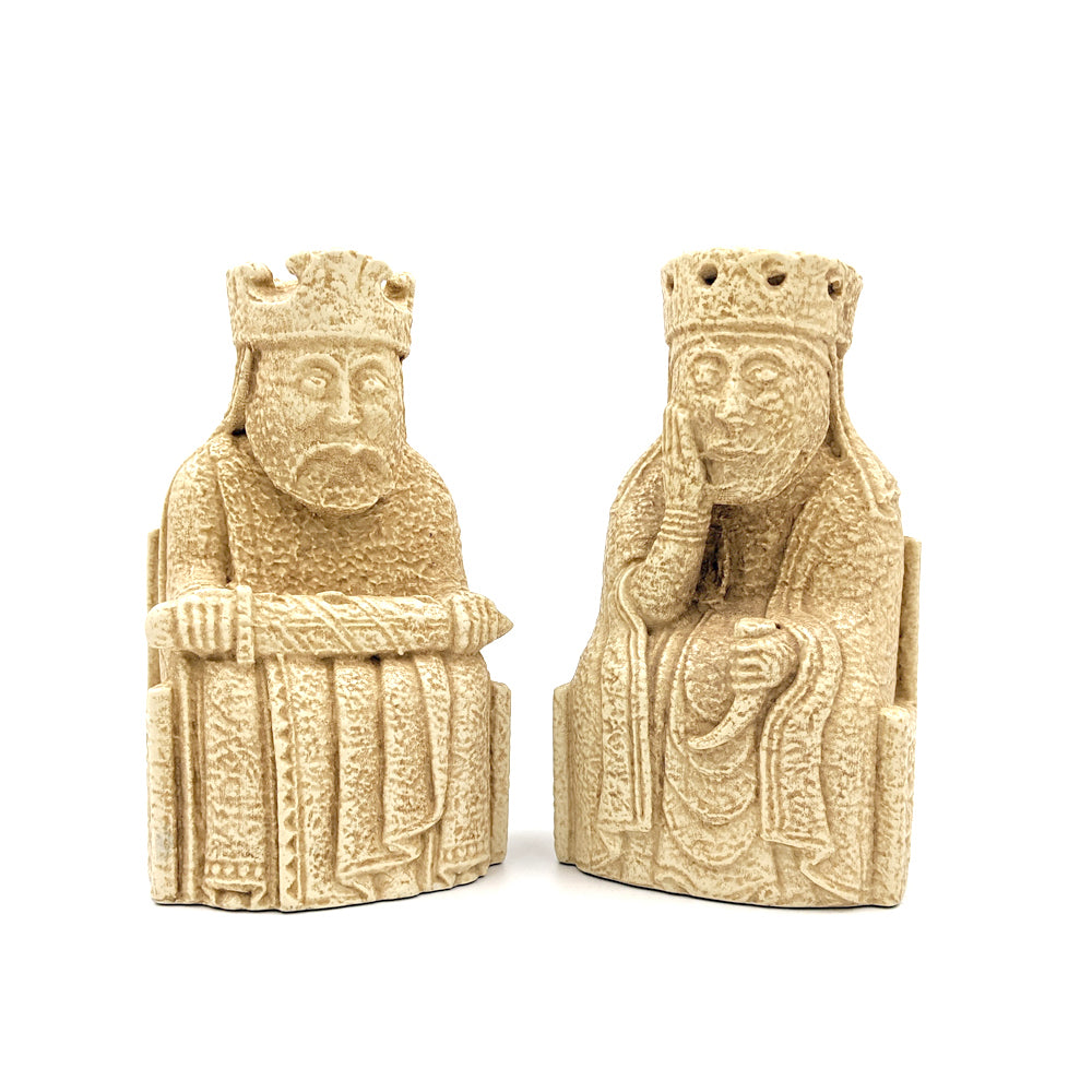 Plastic resin bookends of the king and queen Lewis chess pieces. They sit on thrones with knotwork detailing and wear crowns. The king holding a sword across his knee and the queen is holding a drinking horn.