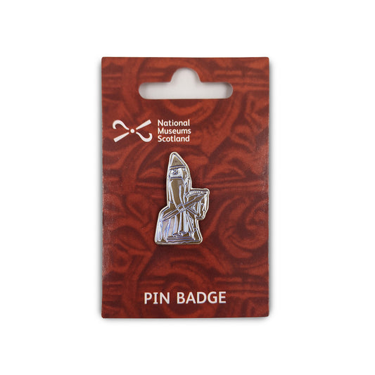 A metal pin badge etched with a line illustration of a knight Lewis chess piece. The pin badge is on a orange backing card  with a faint knot work design, the National Museums Scotland in the top left and the words "Pin Badge" across the bottom edge in white.