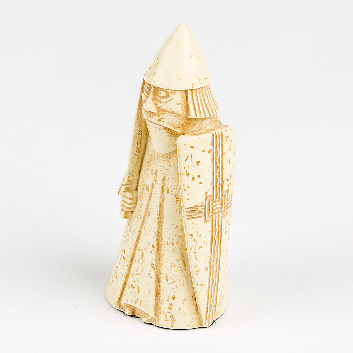 A resin replica of a warder Lewis chess piece. The warder is wearing long robes and a pointed helmet. He is holding a sword in his right hand and a body length shield in his left.