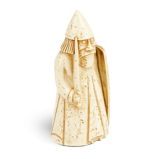 A resin replica of a warder Lewis chess piece. The warder is wearing long robes and a pointed helmet. He is holding a sword in his right hand and a body length shield in his left.