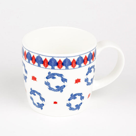 A white bone china mug with a pattern of blue circling fish and red lotus leaves in a Ming inspired style.