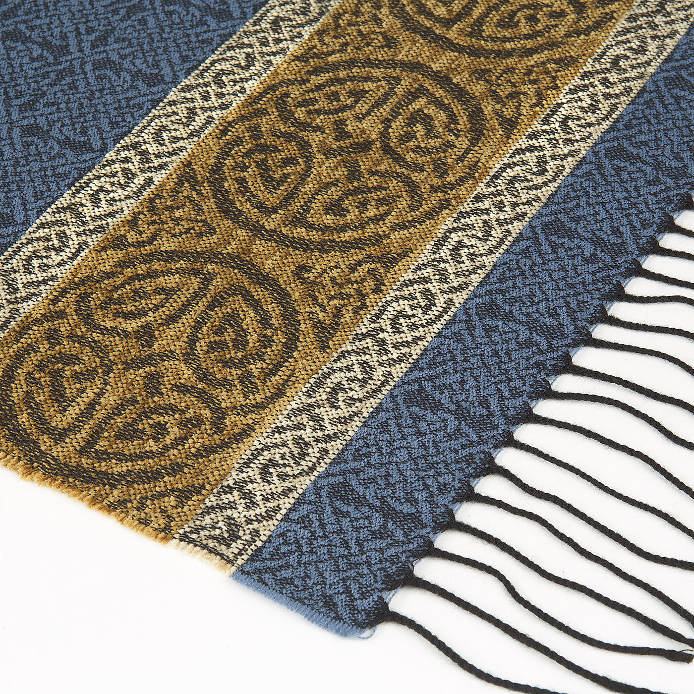 Blue tassled scarf detail with a celtic roundal pattern against a plain white background.