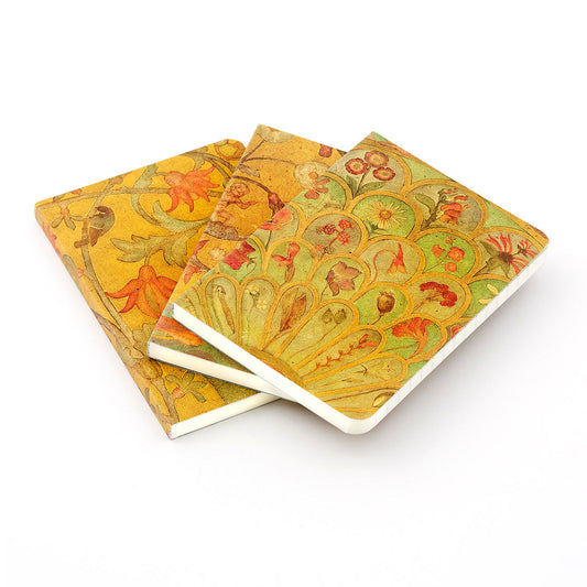 Three fanned out notebooks with painted details from the willowwood piano by Phoebe Anna Traquair on the covers. The details are of various floral designs painted in greens and yellows.