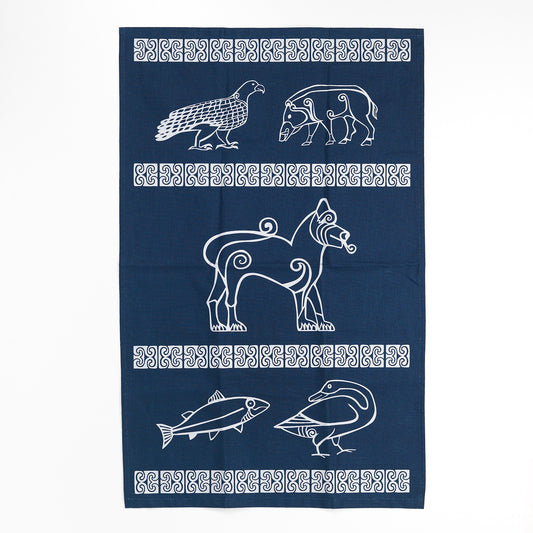 a navy blue cotton tea towel with silver detailing taken from Pictish carvings. across the tea towel are four strips of Pictish pattern work creating three segments of the towel with animal designs also taken from carvings. In the top segment there is an eagle and a boar, in the middle segment there is a large lion, and in the bottom segment there is a fish and a goose.