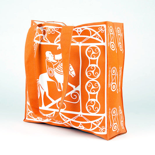 An orange cotton shopper bag with a white printed design taken from Pictish carvings of Pictish pattern work and a man drinking whilst riding a horse.
