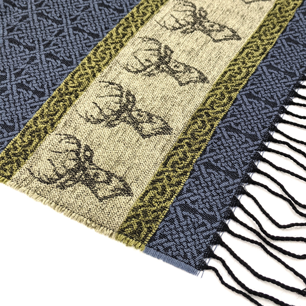Blue and green tassled scarf detail with a celtic roundal and stag pattern against a plain white background.