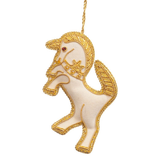 An embroidered hanging decoration of a Scottish unicorn. The decoration is made from white fabric and is embroidered with gold thread