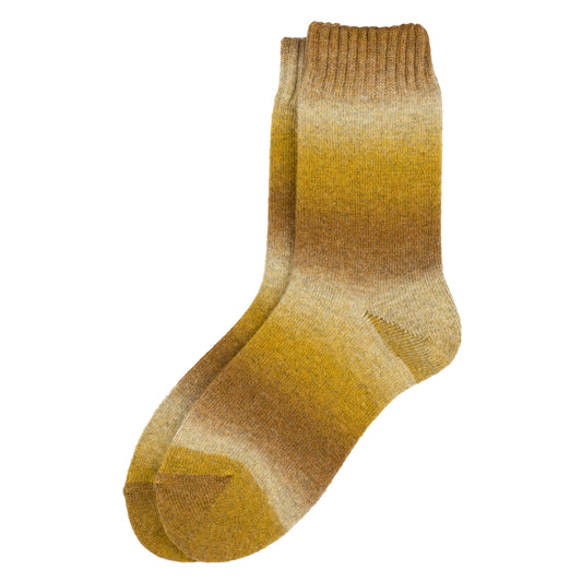 A pair of socks with a varying yellow gradient pattern against a plain white background.