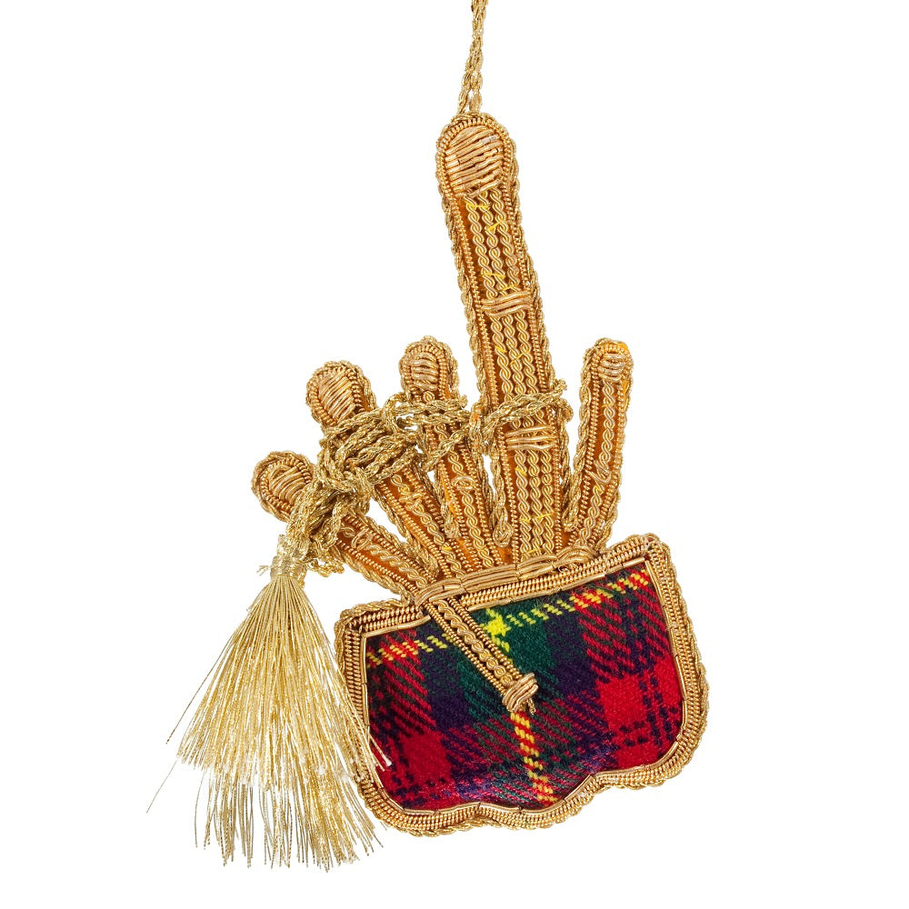 An embroidered hanging decoration of bagpipes. The decoration is made from a red, blue and green tartan fabric and embroidered with gold thread, a gold tassel hangs from the pipes.