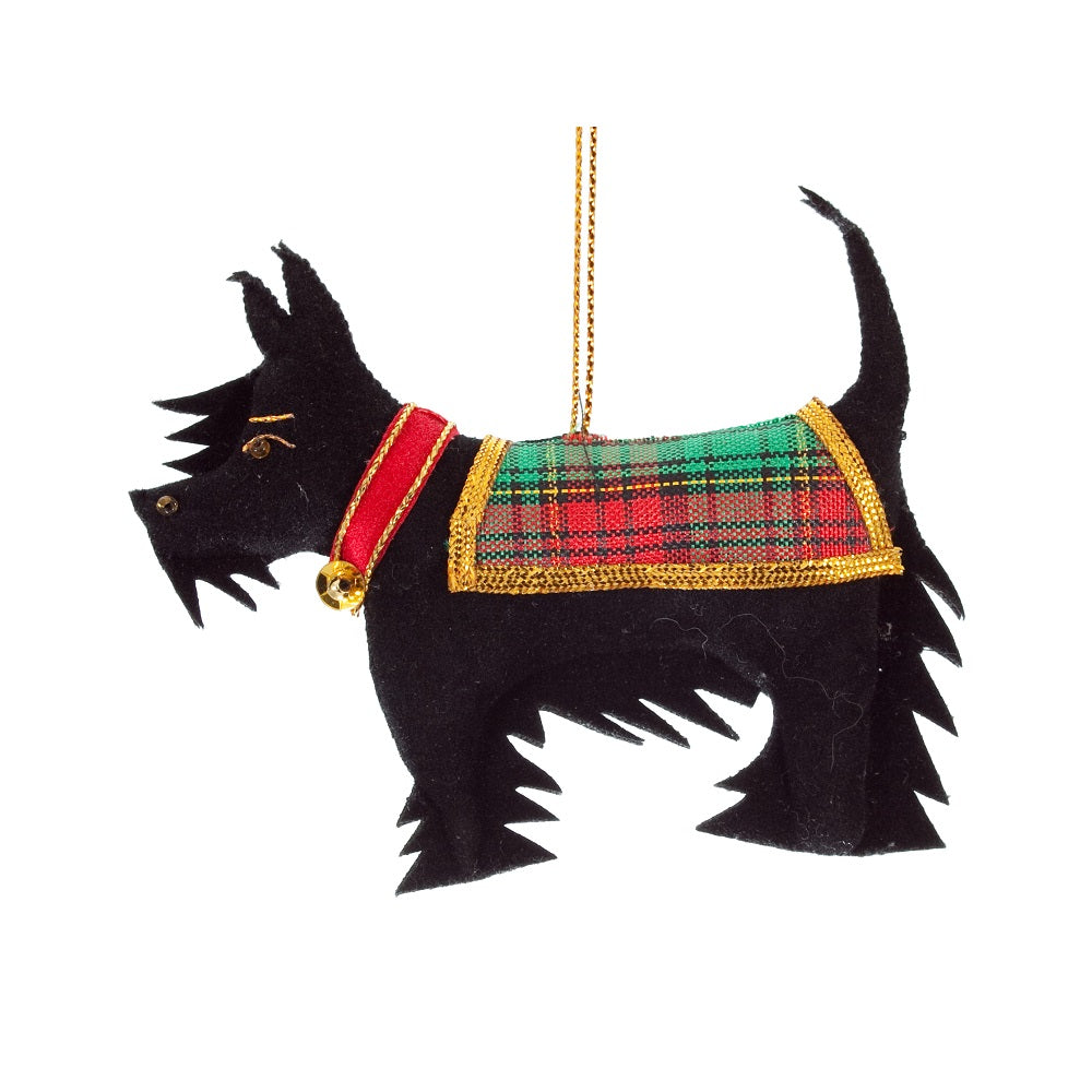 An embroidered decoration of a Scottish terrier wearing a red collar and tartan jacket. The dog is made from black fabric and embroidered with a gold thread.