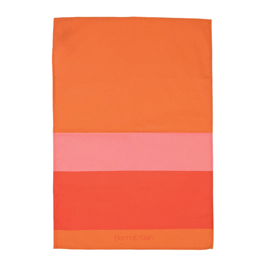 An orange and pink striped cotton tea towel based on Bernat Klein's work against a plain white background.