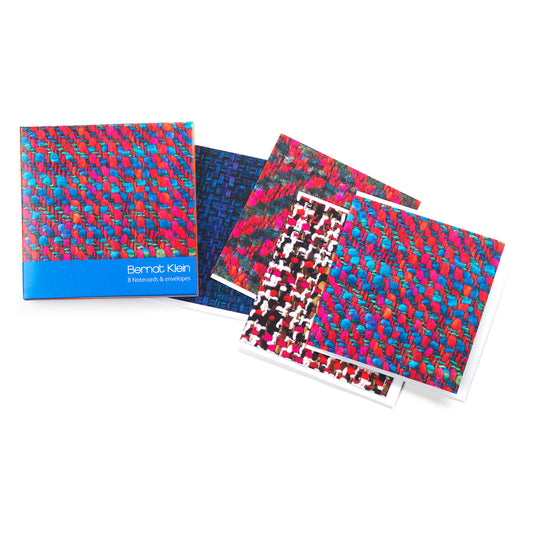 A box, and four cards with various Bernat Klein woven fabrics sat against a plain white background. 