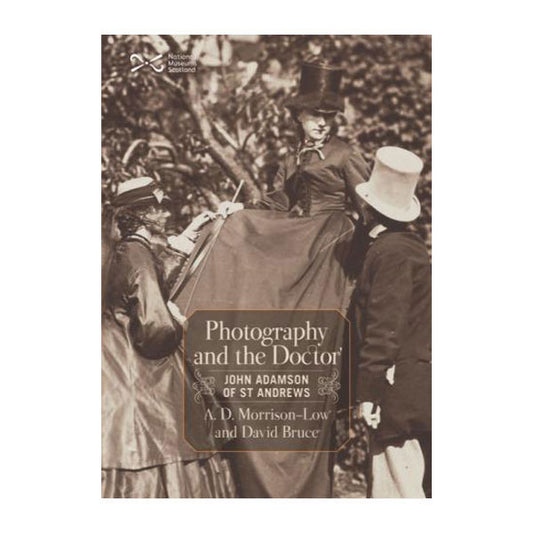 Book cover with a black and white photograph of two women and a man in Victorian clothing in a garden. A woman is sitting on a tree branch wearing a long dress and top hat, she is looking down to the right at a man in a tailcoat and a white top hat, on the left a woman in a dress and veil is leaning onto her knee and looking up at her.