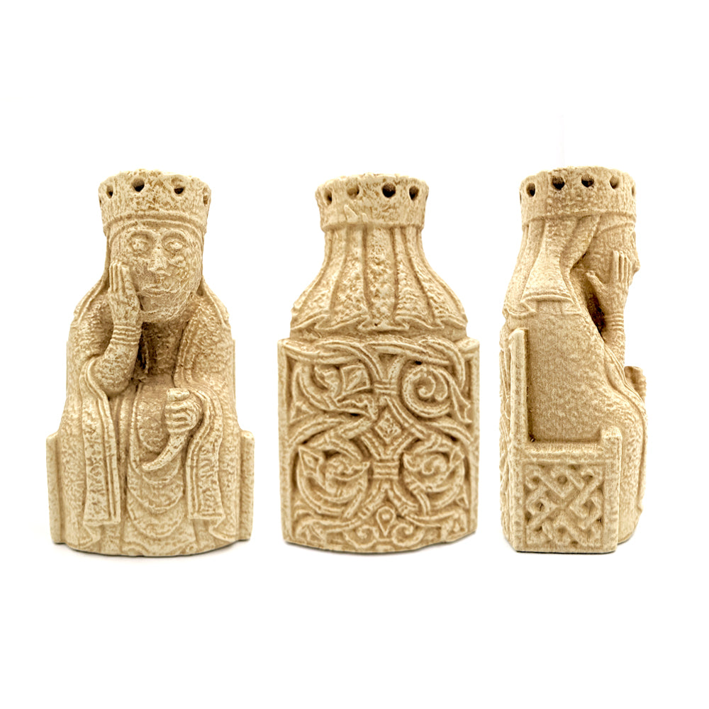 A front, side, and reverse view of a Lewis chessmen queen resin replica bookend. The queen sits on a throne decorated with knot work and is wearing long robes and a crown, her chin rests in her right hand and she holds a drinking horn in her left.